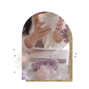 Donna con una tazza tra le mani accanto a cristalli di ametista e quarzo rosa, per il corso di reiki